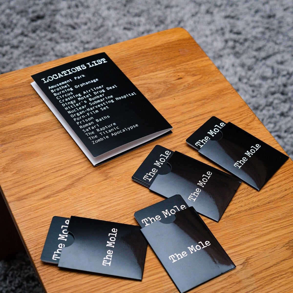Black cards with 'The Mole' text on a wooden surface