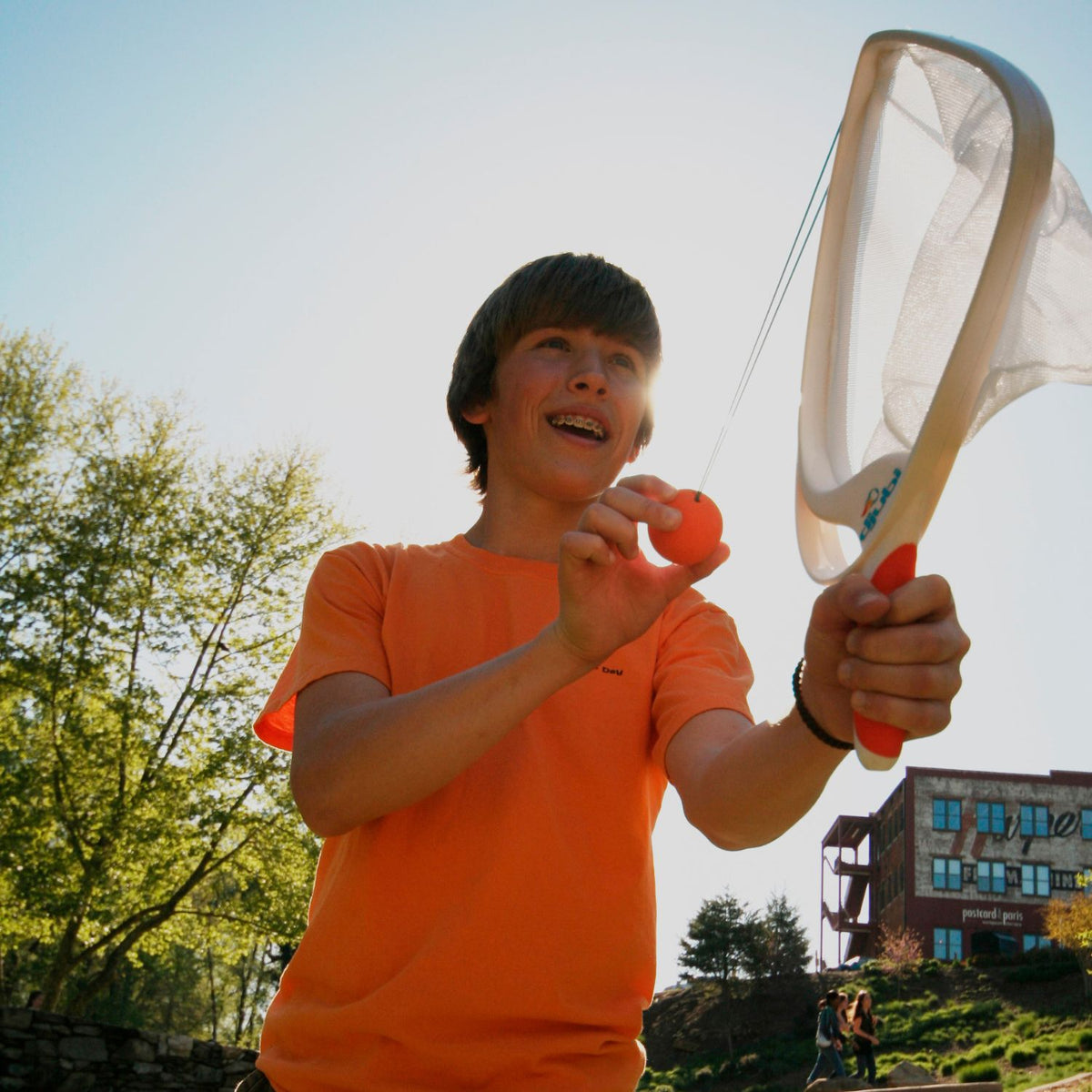 An action shot of a player pulling back the loop ball against the racket hook, aiming into the open sky for a long-distance launch.