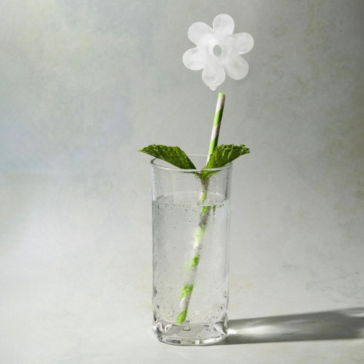 retro-style cocktail glass featuring a large daisy ice cube, illustrating the "groovy" 70s aesthetic and premium beverage presentation.