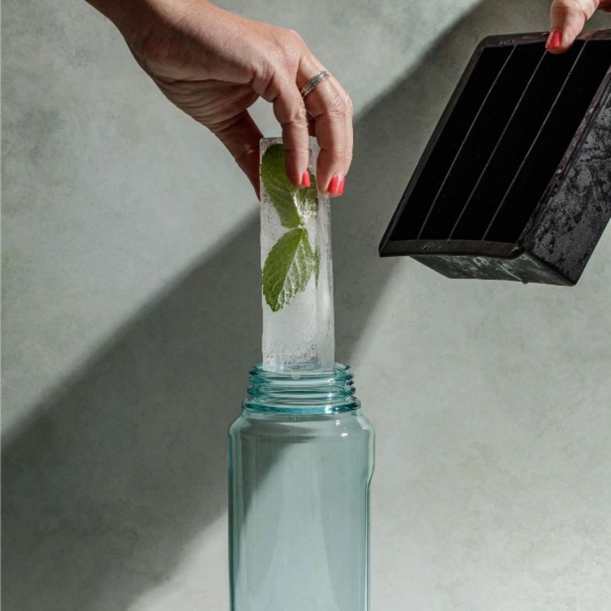 Drinks Plinks Slab ice cube going into a drink bottle with mint