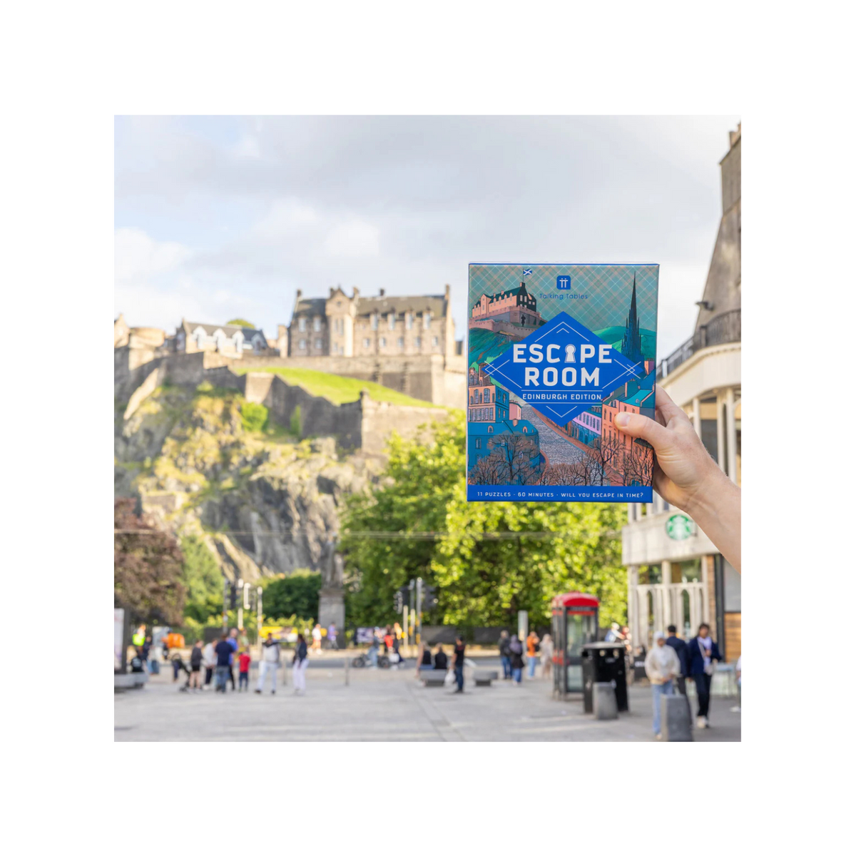 Book titled 'Escape Room Edinburgh' held up with a cityscape in the background