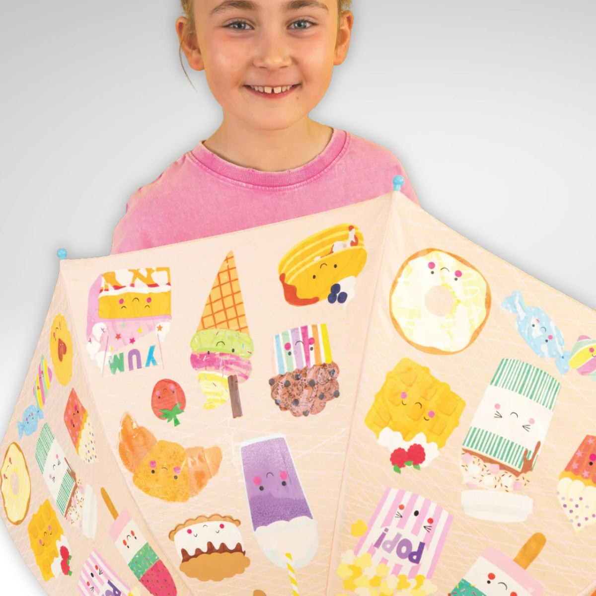 Child holding an umbrella with sweet treat patterns
