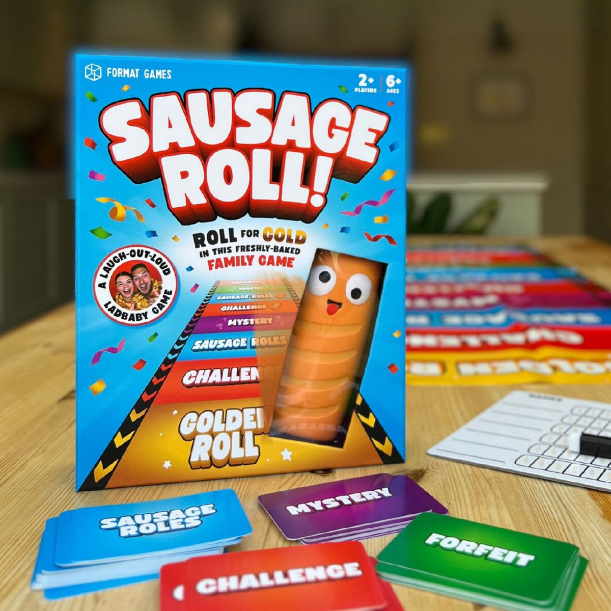 The Sausage Roll Game box set featuring the oversized foam sausage, the roll-out runway mat, and a deck of 75 hilarious challenge cards.