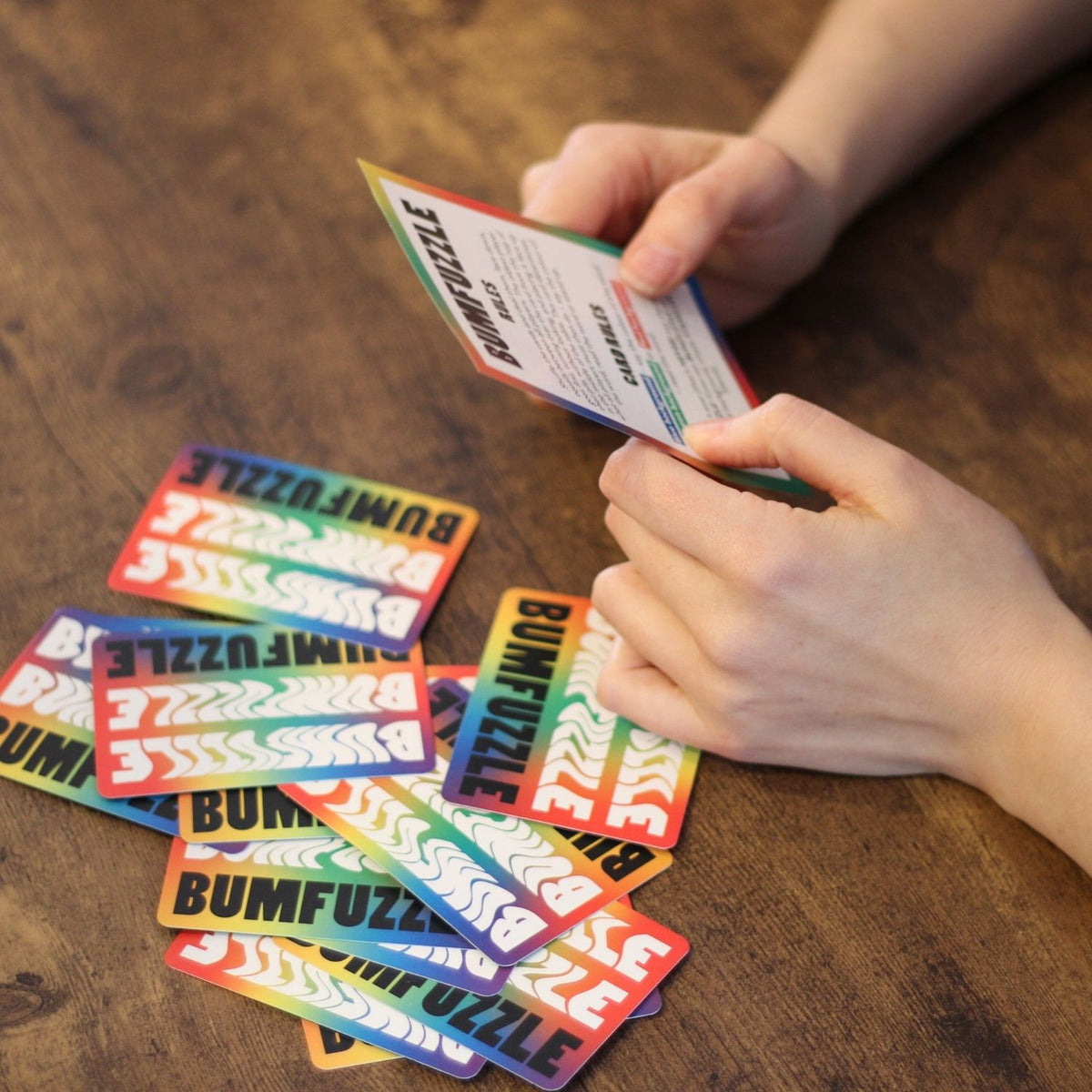 Colorful card game cards with 'BUMFUZZLE' branding on a wooden table.
