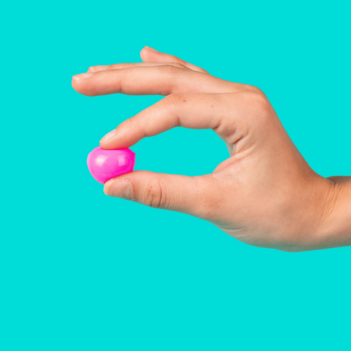 a hand holding one pink paintball