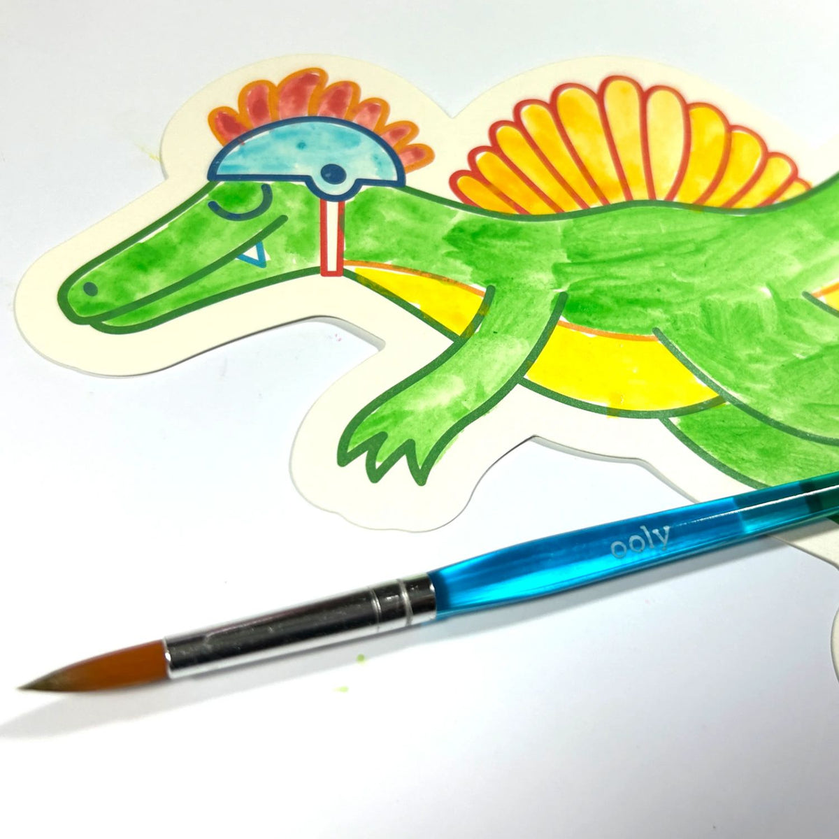 Colourful kids dinosaur illustration with a paintbrush on a white background