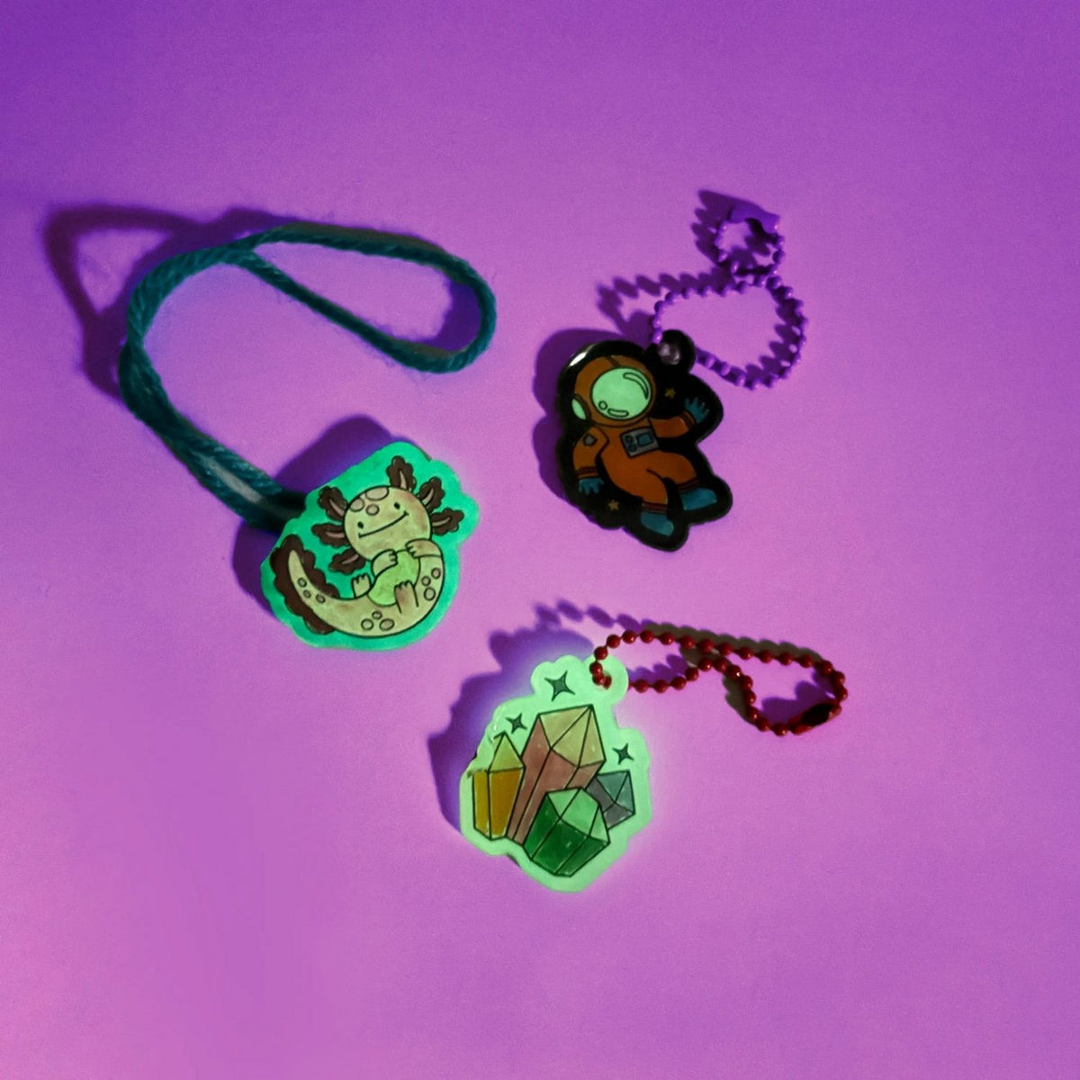 A collection of finished glow-in-the-dark buddies in different colours, showcasing the variety of charms kids can create for friends.
