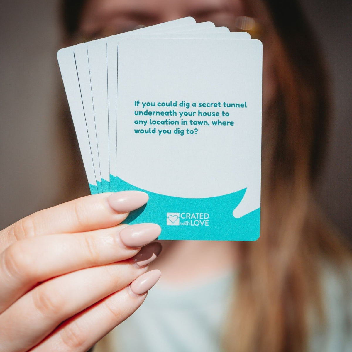 A selection of cards fanned out to show a mix of lighthearted and meaningful questions, showcasing the clean typography and professional design.